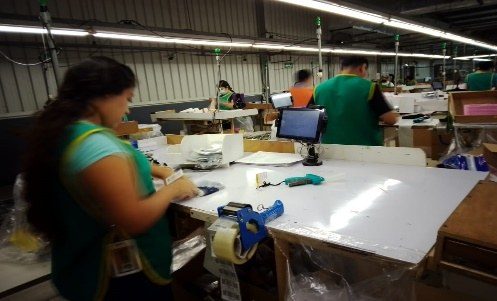 Staff at packing stations preparing finished garments.